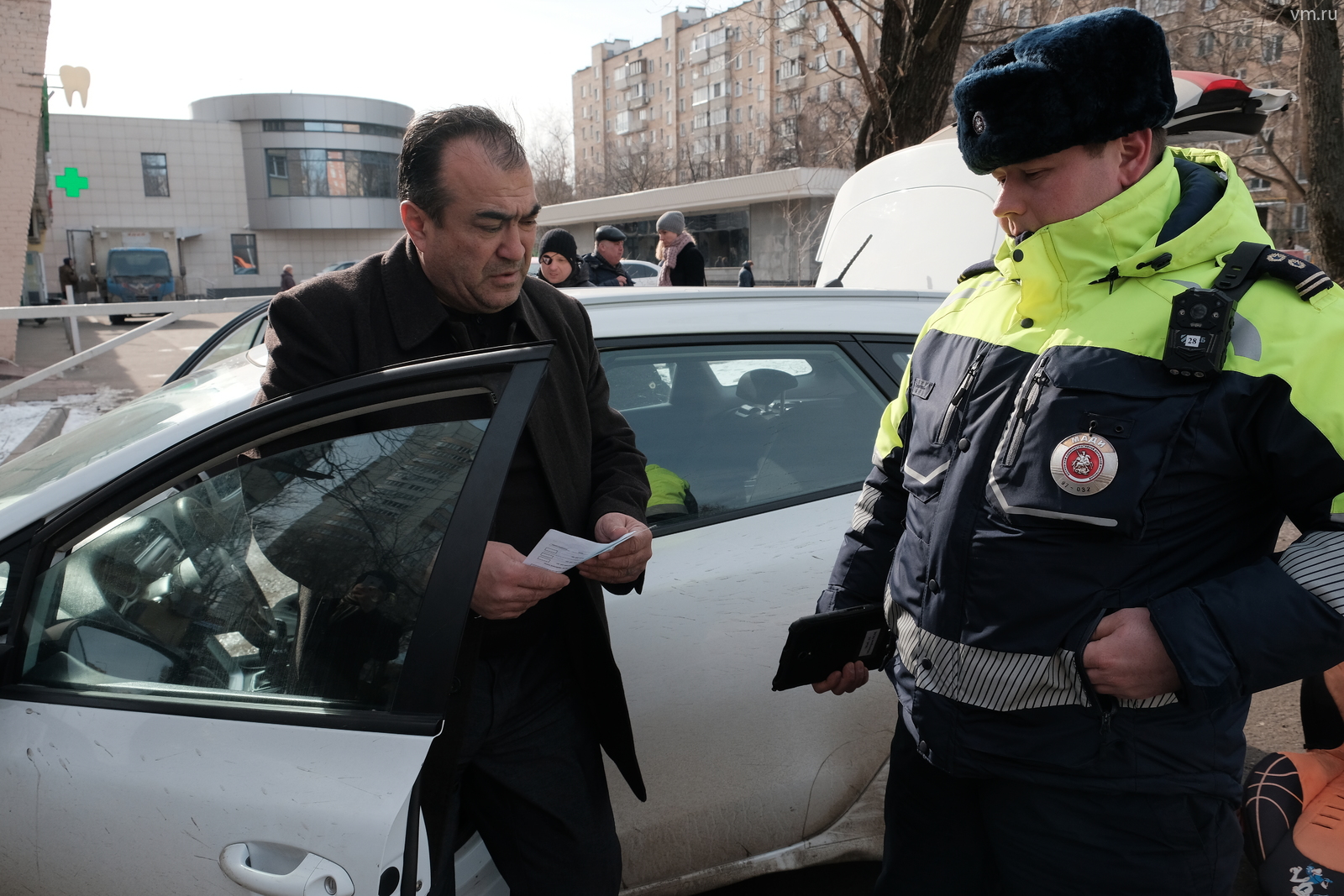 Инспектор МАДИ Михаил Чуланов проверяет документы у таксиста Руслана Магомедова