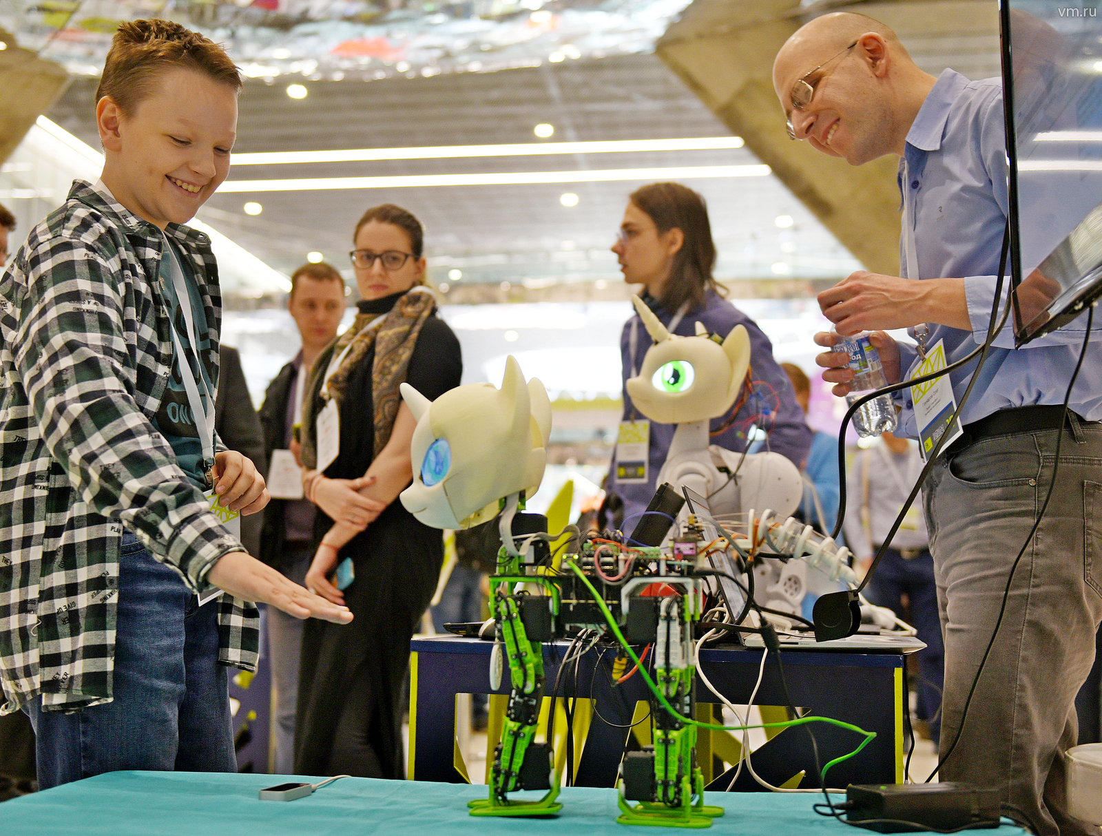 Участник выставки Skolkovo Robotics 2019 Олег Гончаров (справа) демонстрирует юному посетителю технопарка Роману Морозову свой проект — модульного программируемого робота «Свити бот»