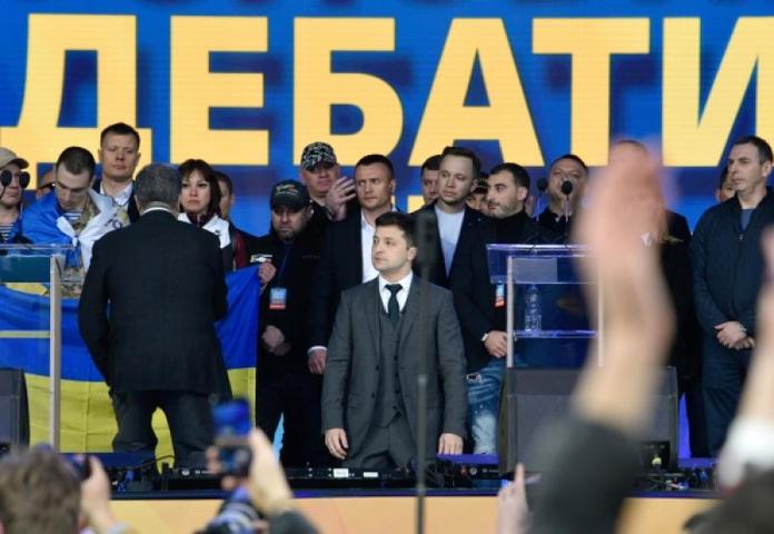 Петр Порошенко (слева, спиной) и Владимир Зеленский (справа) встали на колени в конце дебатов